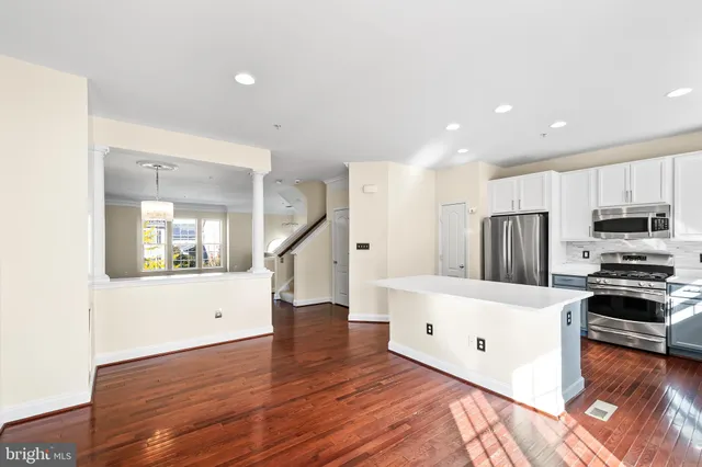 a view of a kitchen with wooden floor and a chandelier