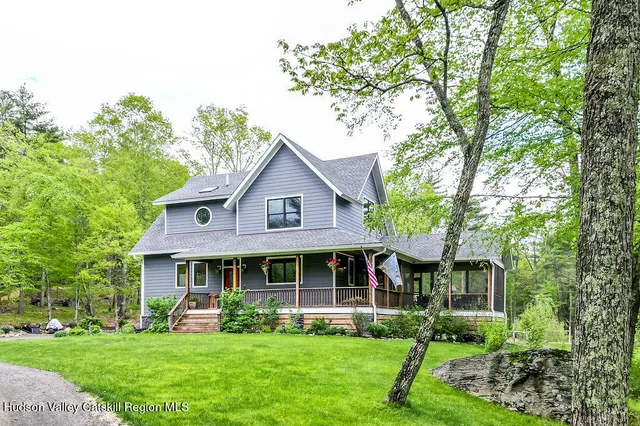 a front view of a house with garden and trees