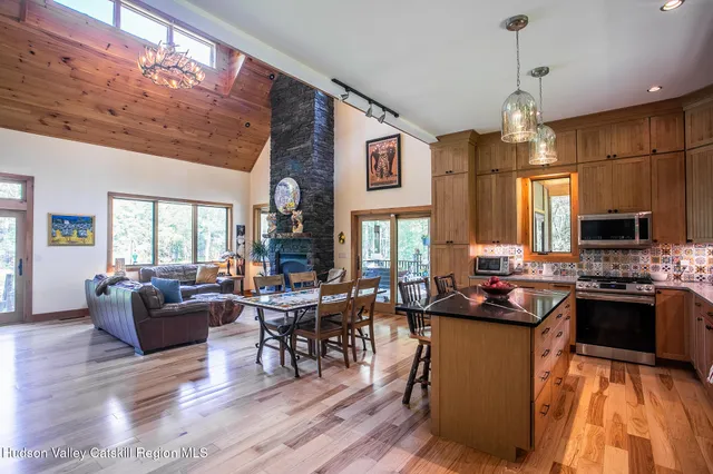 a living room with furniture a fireplace and a floor to ceiling window