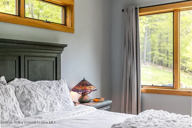 a bedroom with a bed and a dresser next to a window