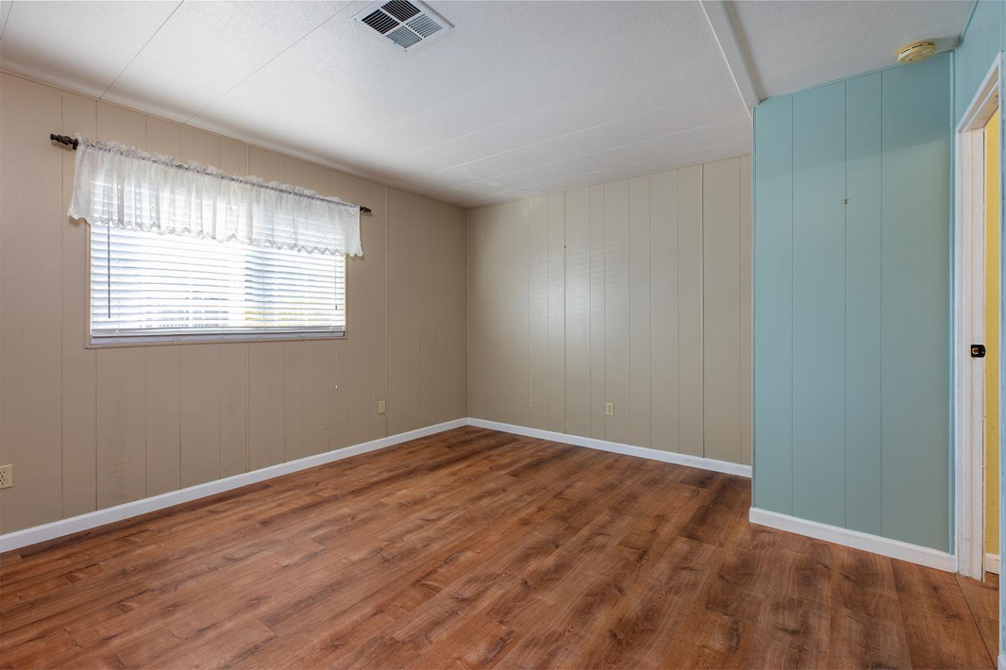 2155 Wharf Road, Unit 12 Capitola, CA 95010 - Photo 15 of 19 an empty room with wooden floor and windows