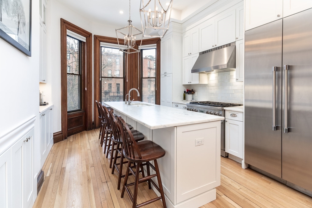23 Braddock Park, Unit 2 Boston, MA 02116 - Photo 1 of 22 a kitchen with stainless steel appliances a dining table chairs refrigerator and sink