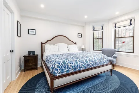 a bedroom with a bed wooden floor and window