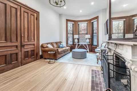 a living room with furniture a fireplace and large window