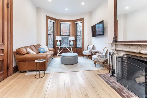 a living room with furniture a flat screen tv and a fireplace