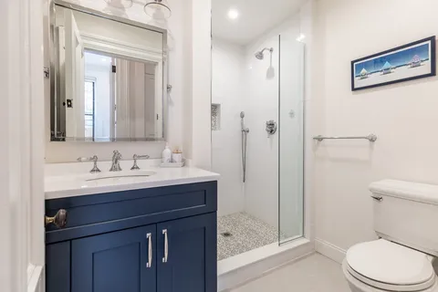 a bathroom with a sink a toilet and shower