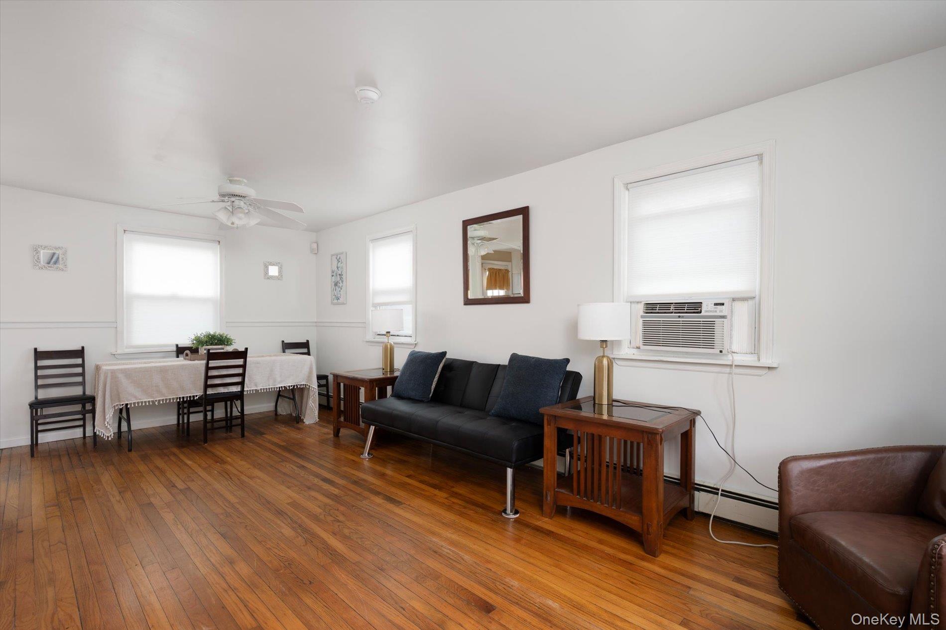 675 Little E Neck Road West Babylon, NY 11704 - Photo 3 of 20 a living room with furniture a dining table and wooden floor
