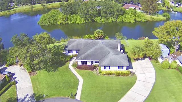 an aerial view of a house with a garden and lake view