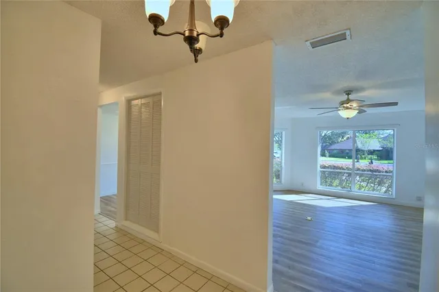 a view of a hallway with wooden floor and a bathroom