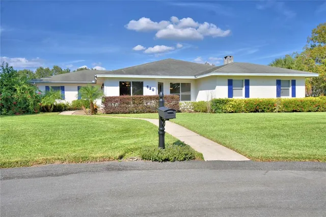 an empty room with window ceiling fan and wooden floor
