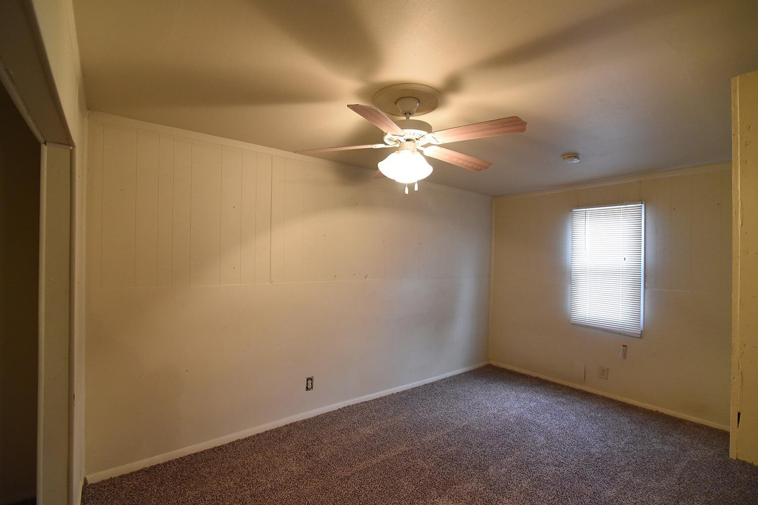 2006 29th Street, Unit REAR Lubbock, TX 79411 - Photo 3 of 10 an empty room with windows and fan