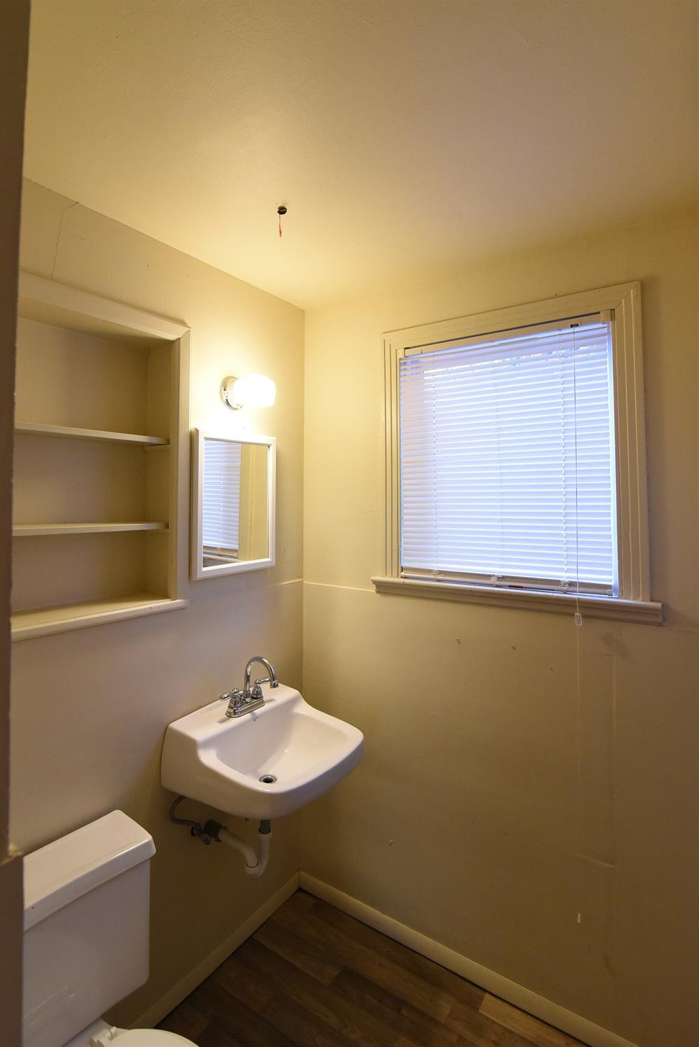 2006 29th Street, Unit REAR Lubbock, TX 79411 - Photo 5 of 10 a bathroom with a sink a toilet and mirror
