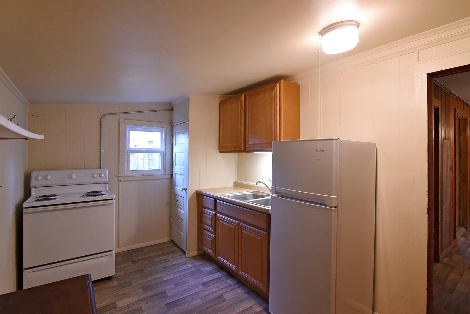 2006 29th Street, Unit REAR Lubbock, TX 79411 - Photo 6 of 10 a kitchen with a refrigerator sink and cabinets