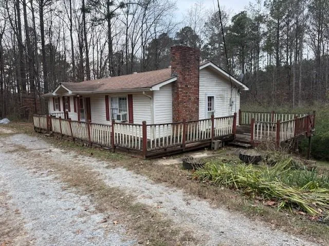 a view of a small yard in front of a house with large trees