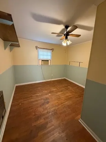 en empty room with a fan and a ceiling fan