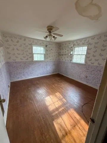en empty room with windows and ceiling fan view