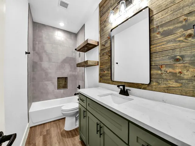 a bathroom with a sink a toilet and shower