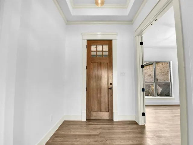 a view of a hallway with wooden floor and windows
