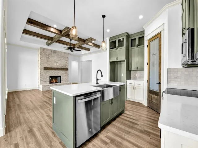 a kitchen with stainless steel appliances granite countertop a sink a stove and a refrigerator