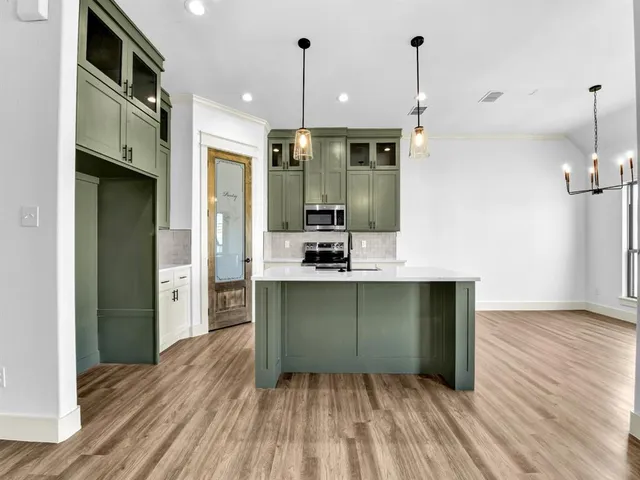 a open kitchen with a sink a refrigerator and wooden floor
