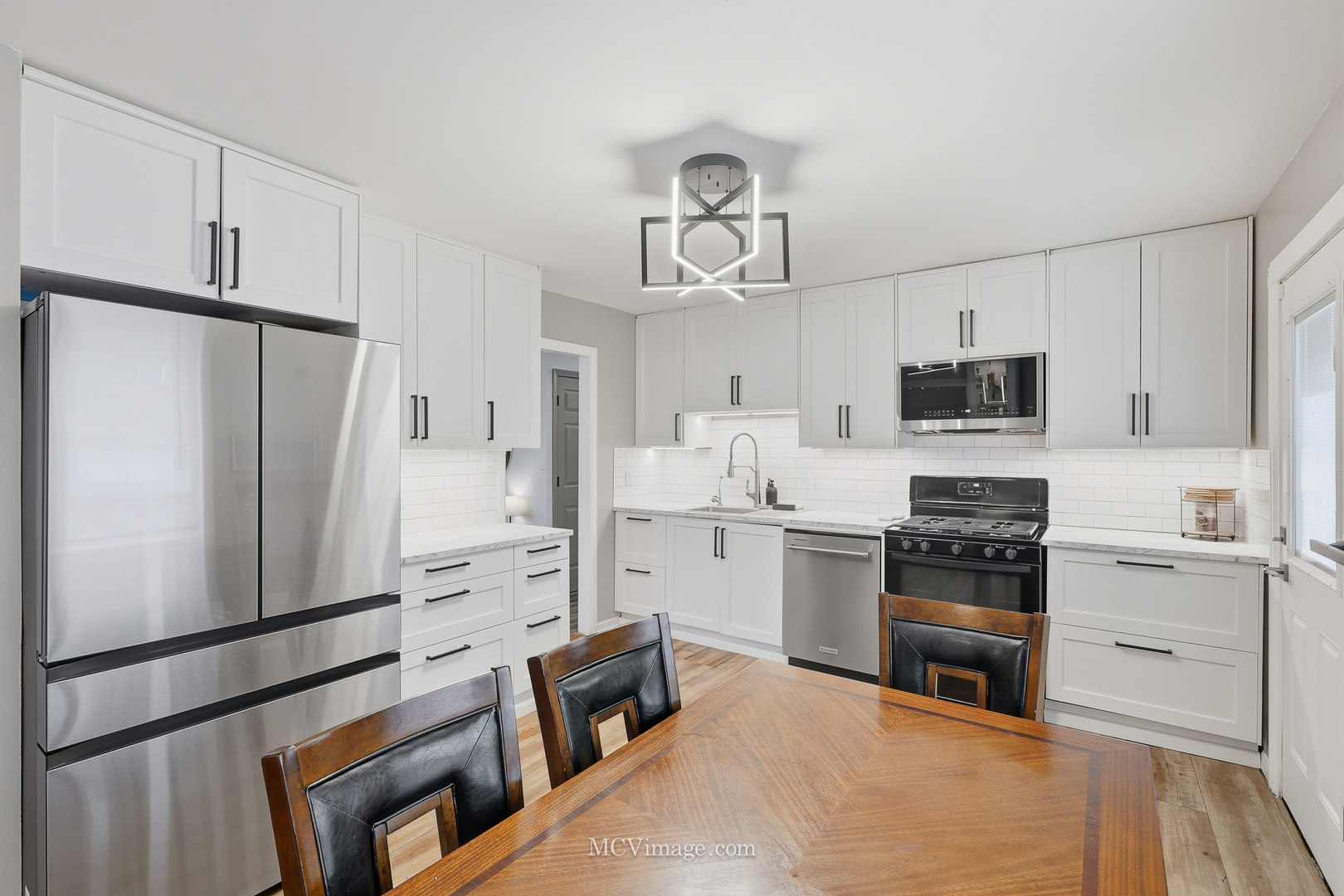 242 Tallman Avenue Romeoville, IL 60446 - Photo 15 of 25 a kitchen with white cabinets and stainless steel appliances