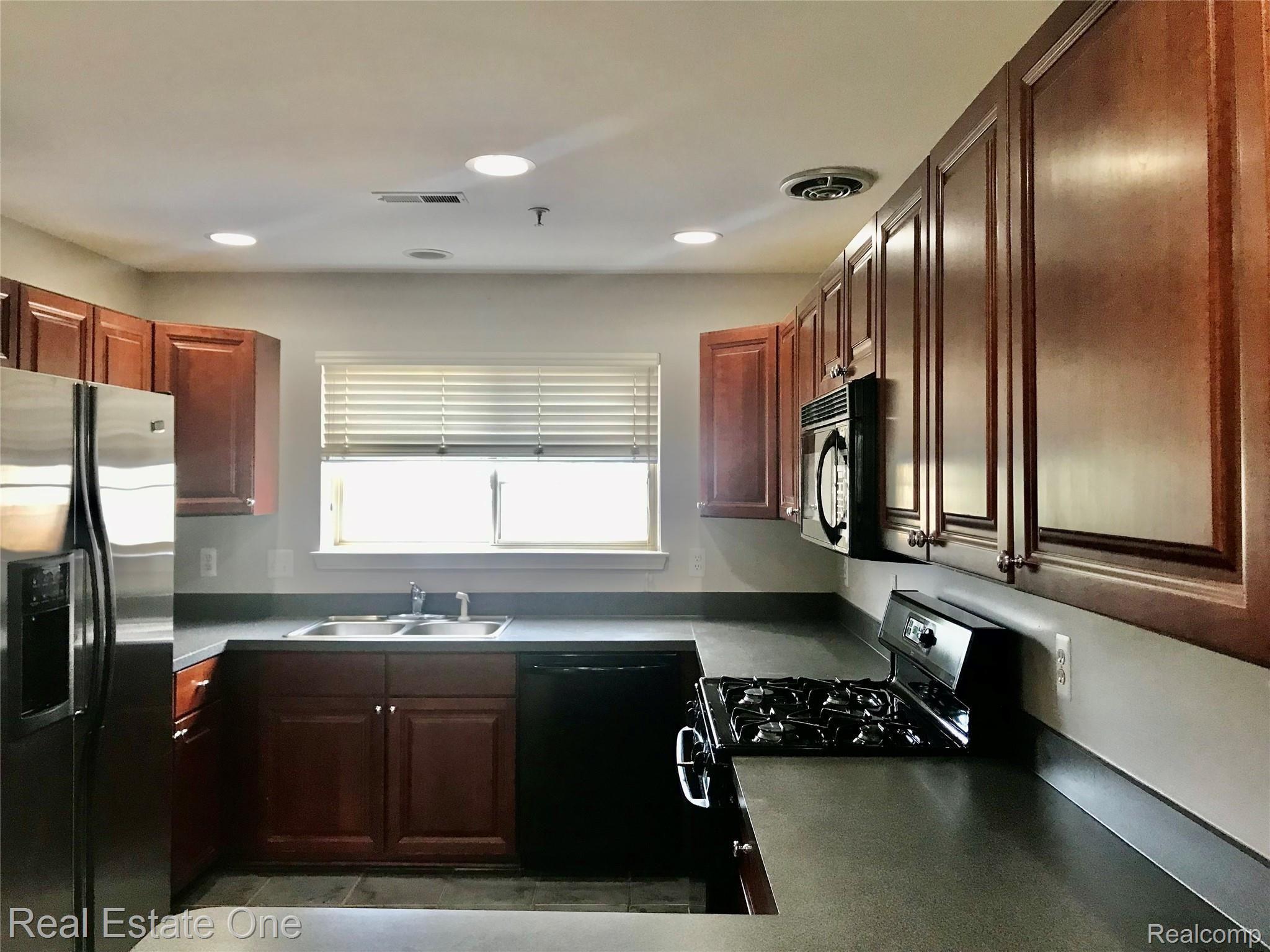 16918 Farmington Road Livonia, MI 48154 - Photo 5 of 21 KITCHEN WITH APPLIANCES AND SS REFRIGERATOR