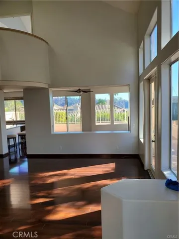 a living room with couches bookshelf and a large window
