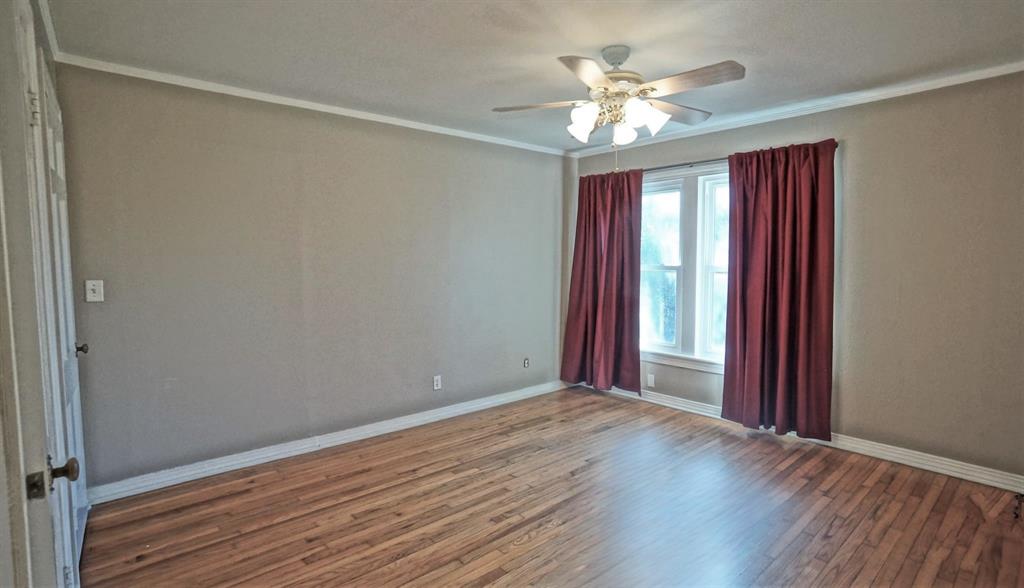 3567 Dryden Road Fort Worth, TX 76109 - Photo 7 of 13 Spare room featuring wood finished floors, a ceiling fan, and ornamental molding
