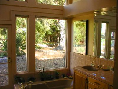 Large master bath has wonderful garden views and a separate tiled shower.