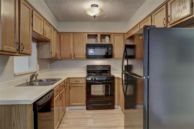 a kitchen with stainless steel appliances granite countertop a stove a sink and a refrigerator