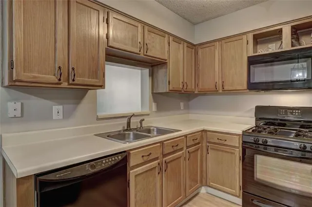 a kitchen with granite countertop a sink stove and cabinets
