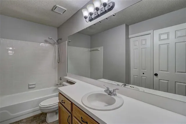 a bathroom with a sink a toilet and a large mirror