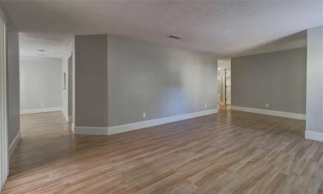 a view of an empty room with wooden floor