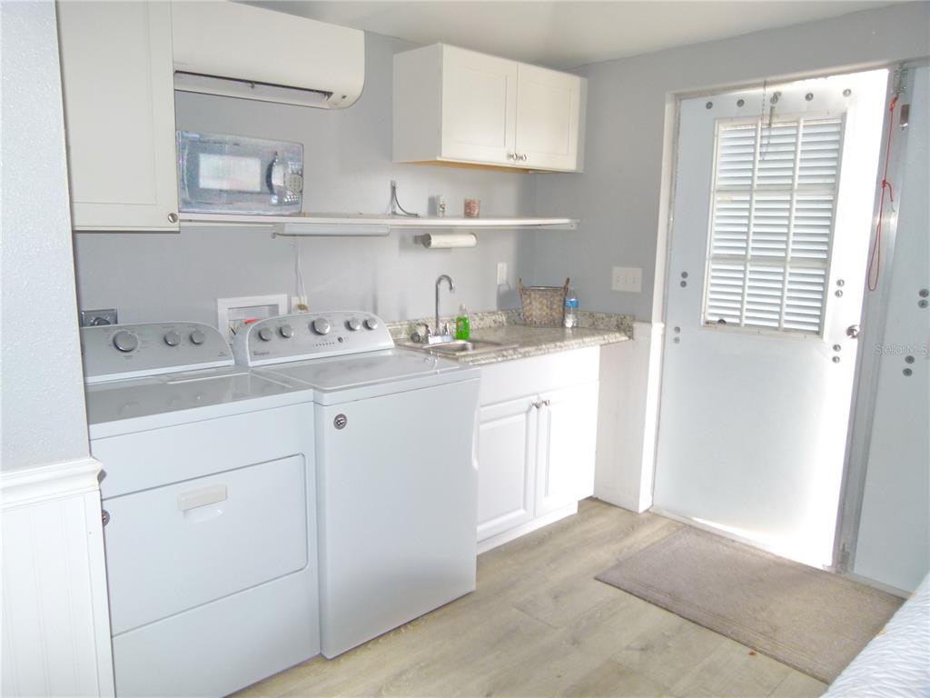 3520 Southwest 7th Manor, Unit 357 Okeechobee, FL 34974 - Photo 7 of 22 a kitchen with white cabinets appliances a sink and a window