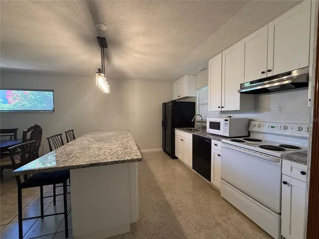 a kitchen with stainless steel appliances granite countertop a sink dishwasher stove top oven and refrigerator