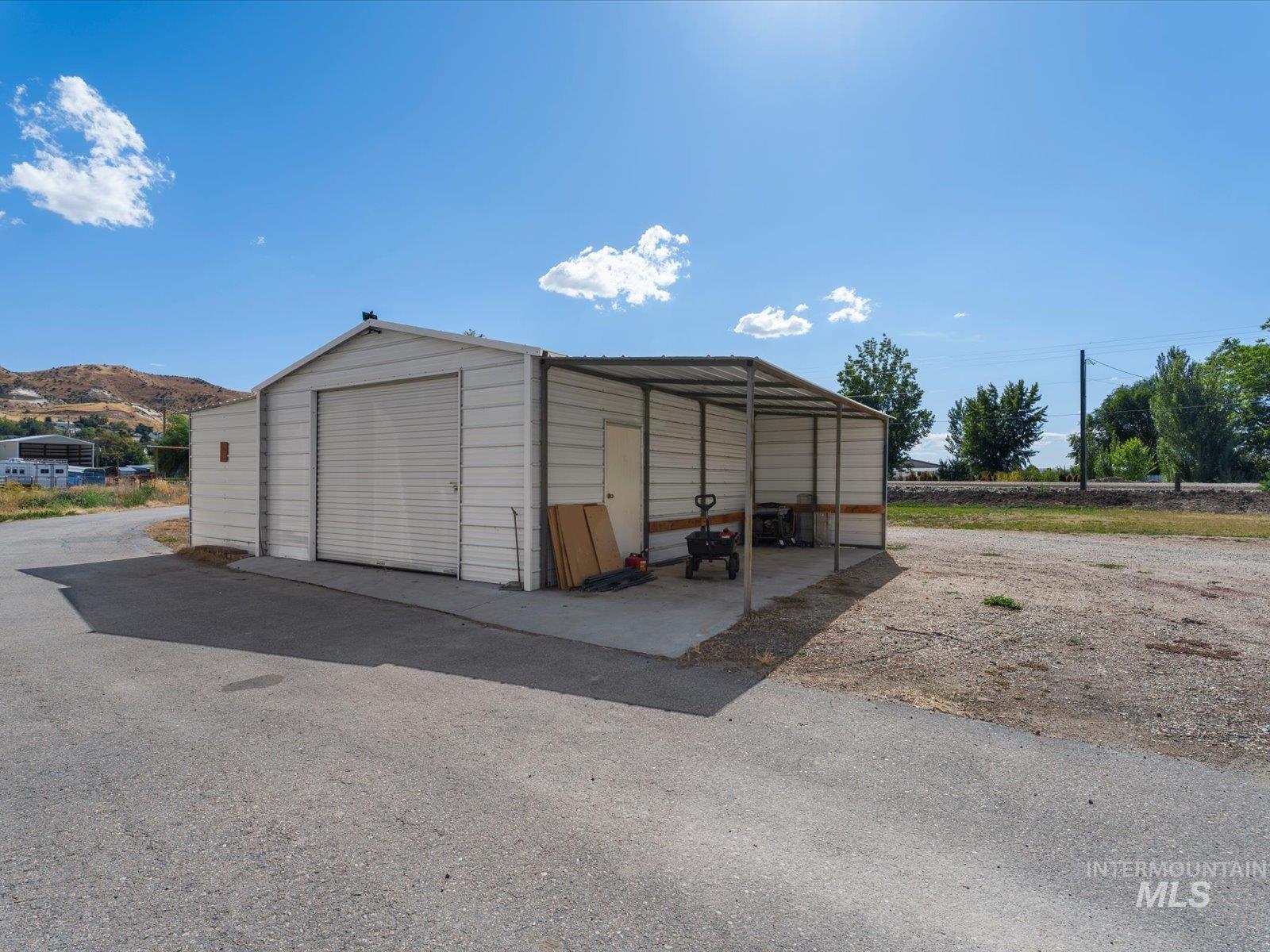 3540 Wills Road Emmett, ID 83617 - Photo 25 of 36 Steel outbuilding featuring a roll-up garage door and an integrated covered carport