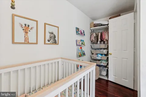 a hallway with a baby crib and wooden floor