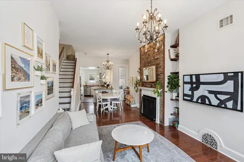a living room with furniture a dining table and a chandelier