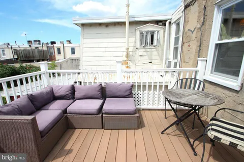 a roof deck with couches and wooden floor