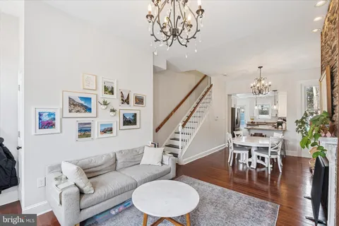 a living room with furniture and a dining table with wooden floor
