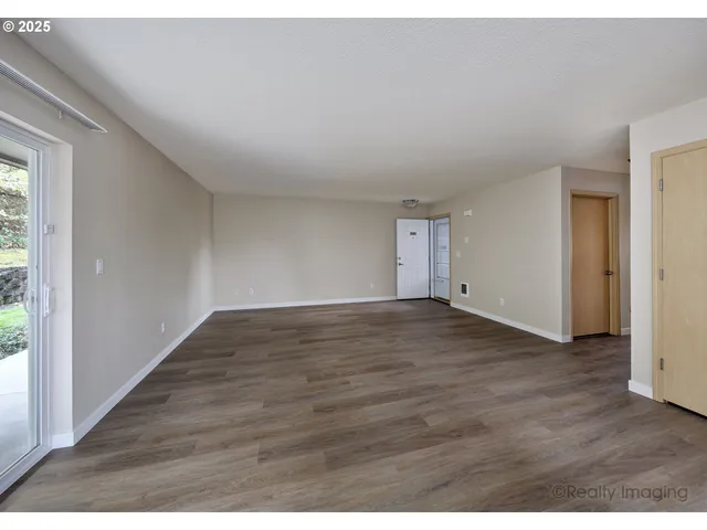 a view of an empty room and wooden floor