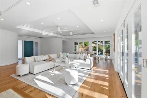 a living room with furniture large window and wooden floor