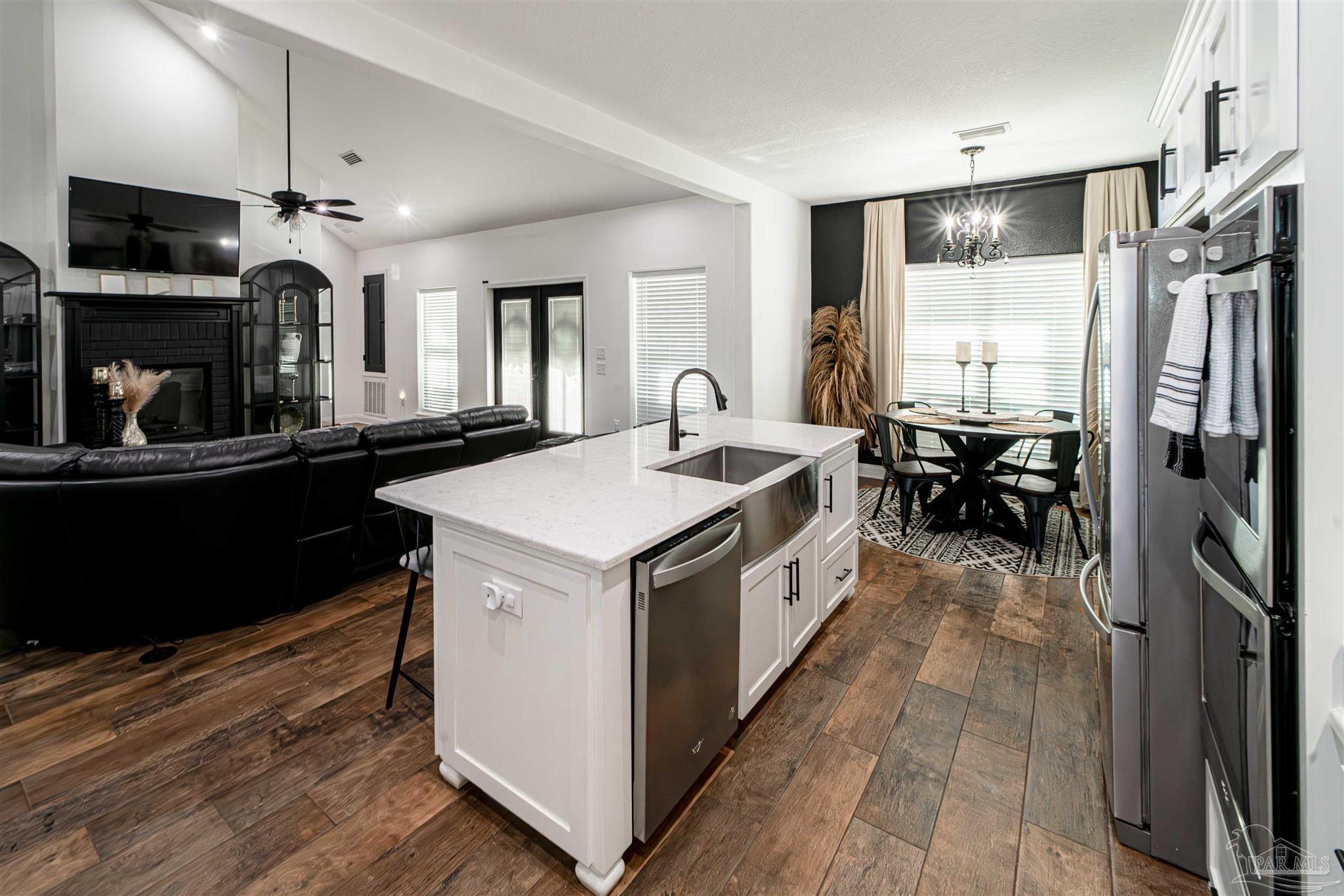 8165 Chumuckla Highway Pace, FL 32571 - Photo 13 of 50 a kitchen that has a lot of cabinets in it and wooden floors