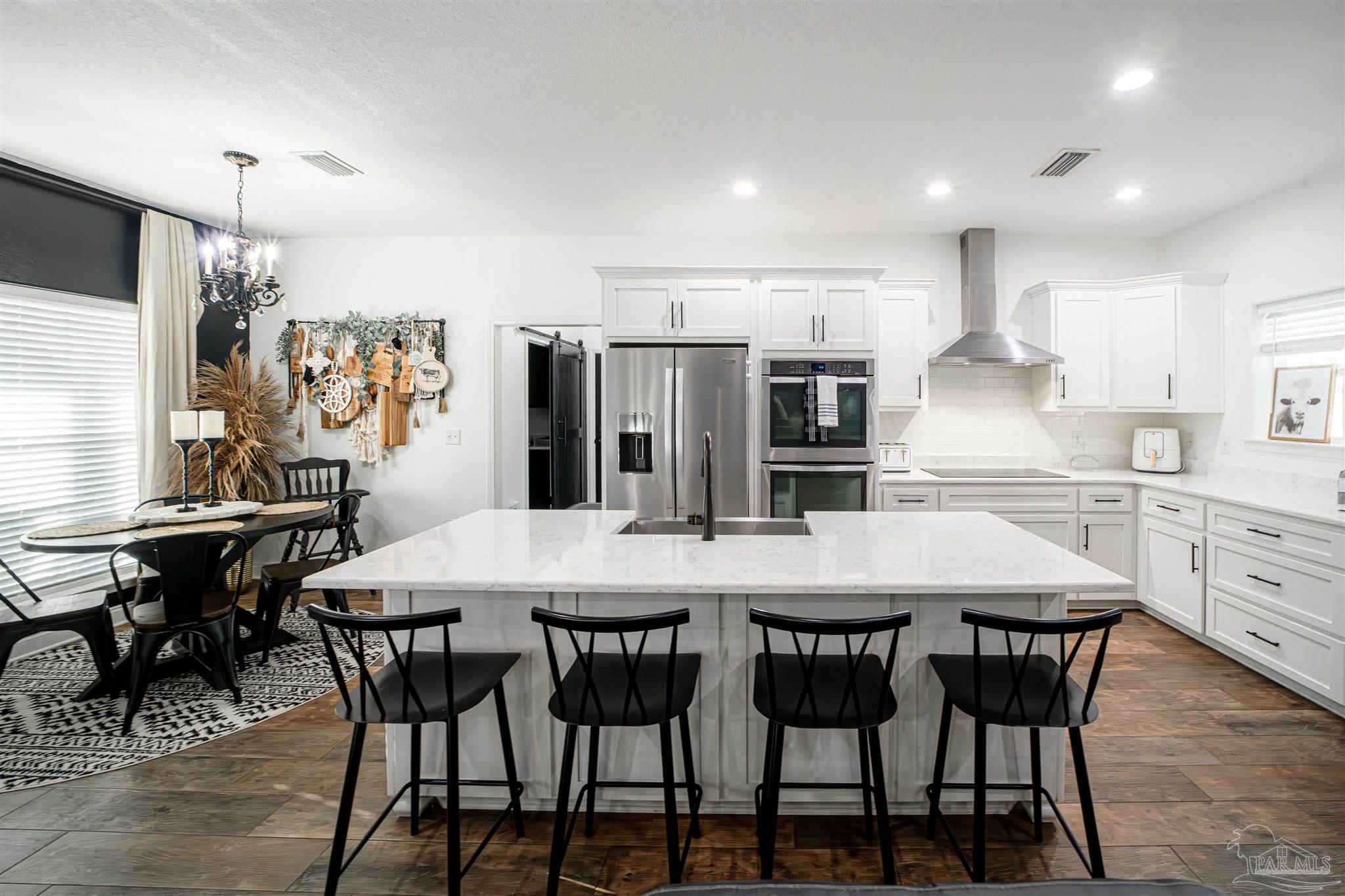 8165 Chumuckla Highway Pace, FL 32571 - Photo 14 of 50 a kitchen with a table and chairs in it