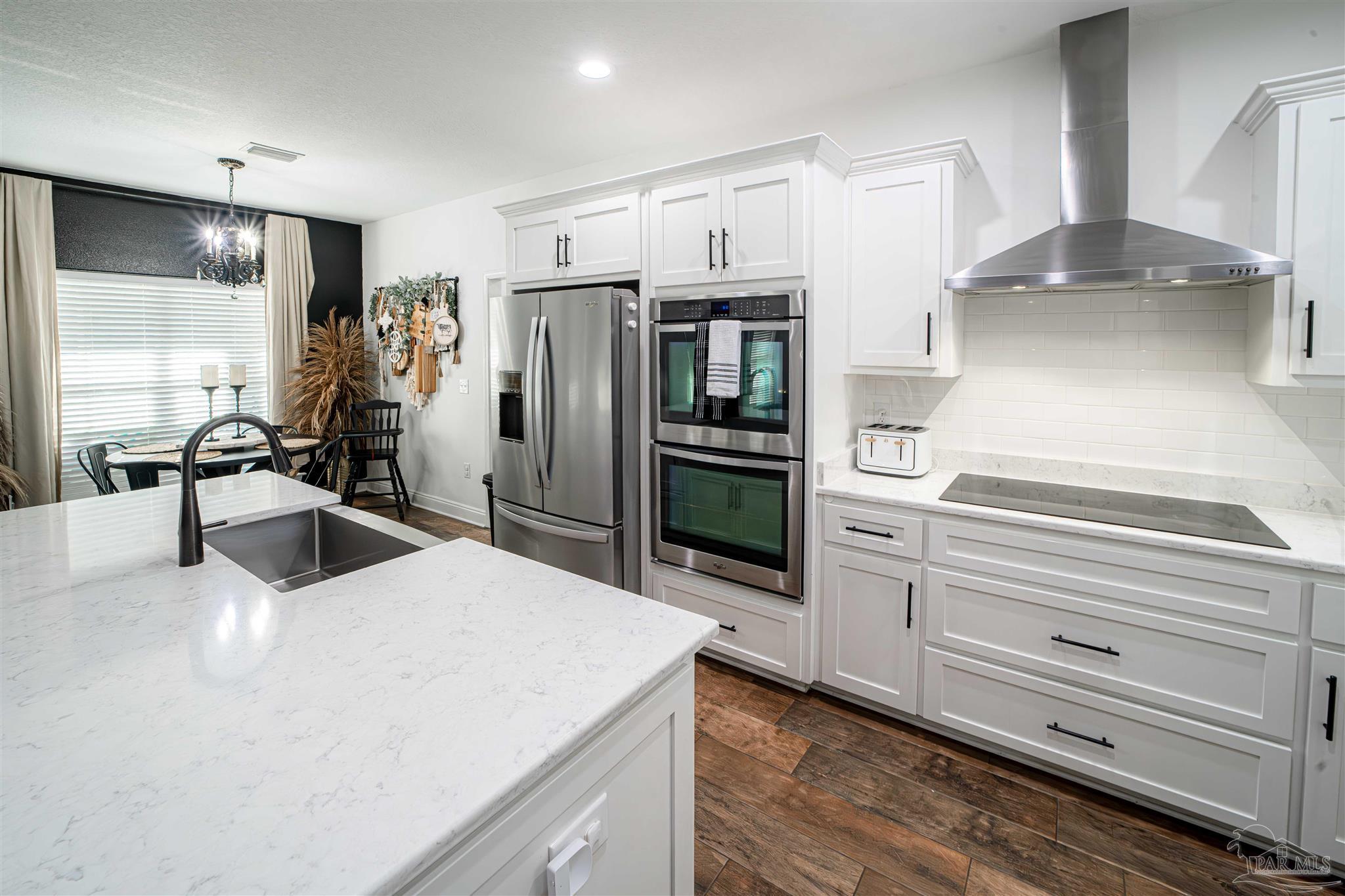 8165 Chumuckla Highway Pace, FL 32571 - Photo 15 of 50 a kitchen with granite countertop a refrigerator stove and sink