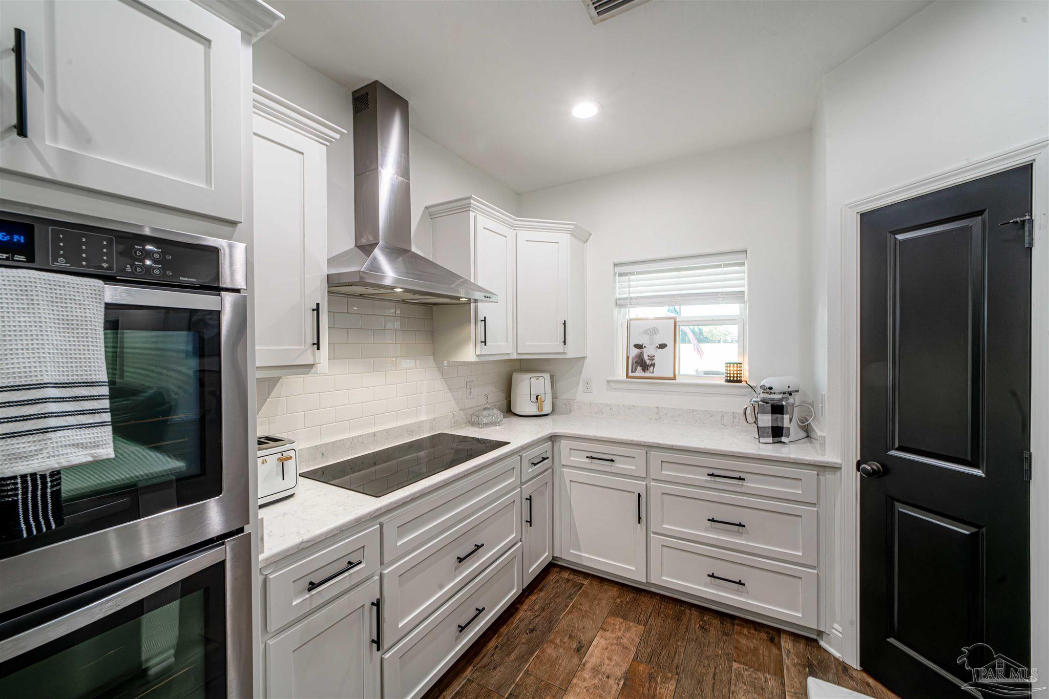 8165 Chumuckla Highway Pace, FL 32571 - Photo 17 of 50 a kitchen with white cabinets and appliances