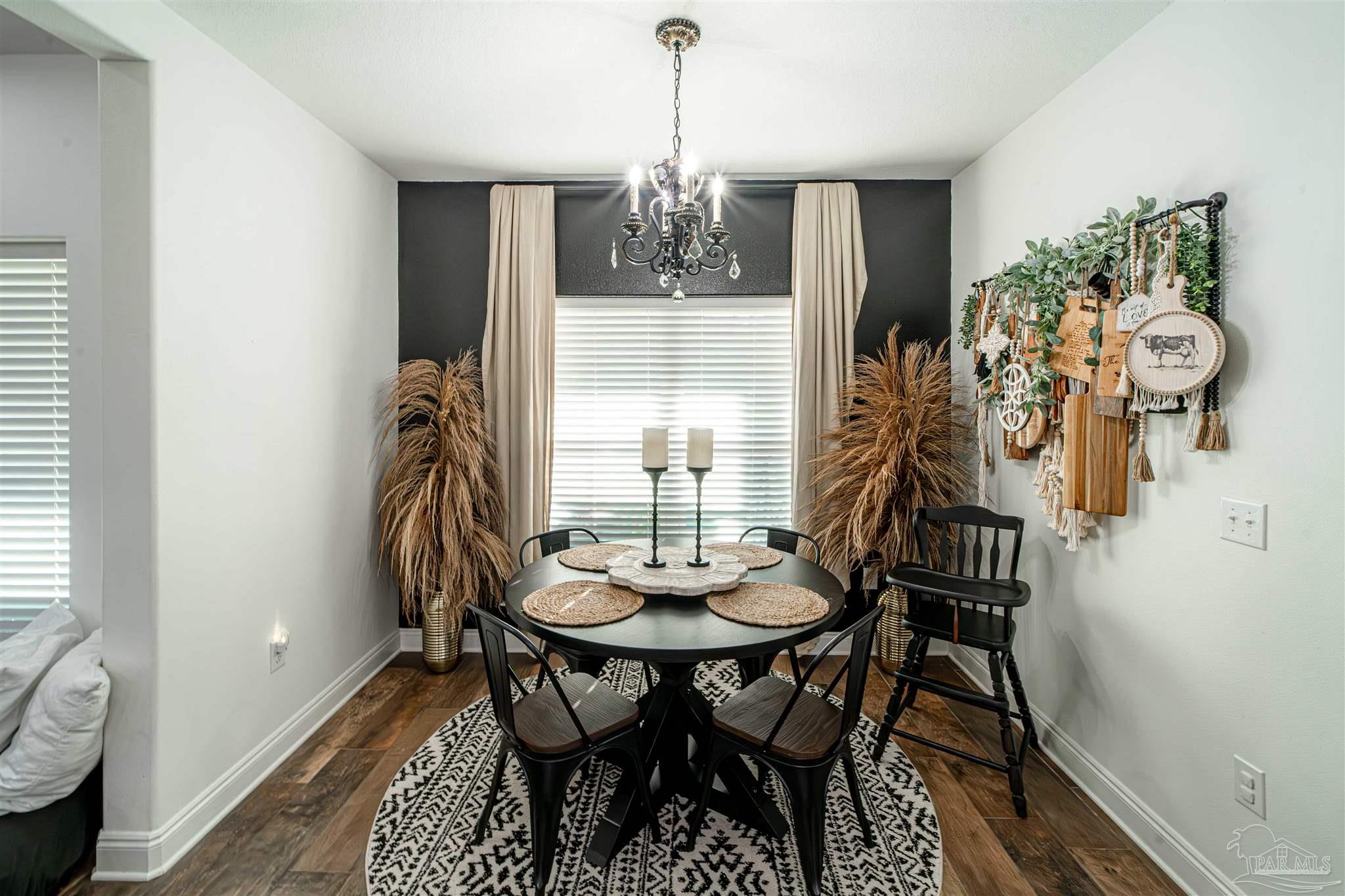 8165 Chumuckla Highway Pace, FL 32571 - Photo 19 of 50 a view of a dining room with furniture and chandelier