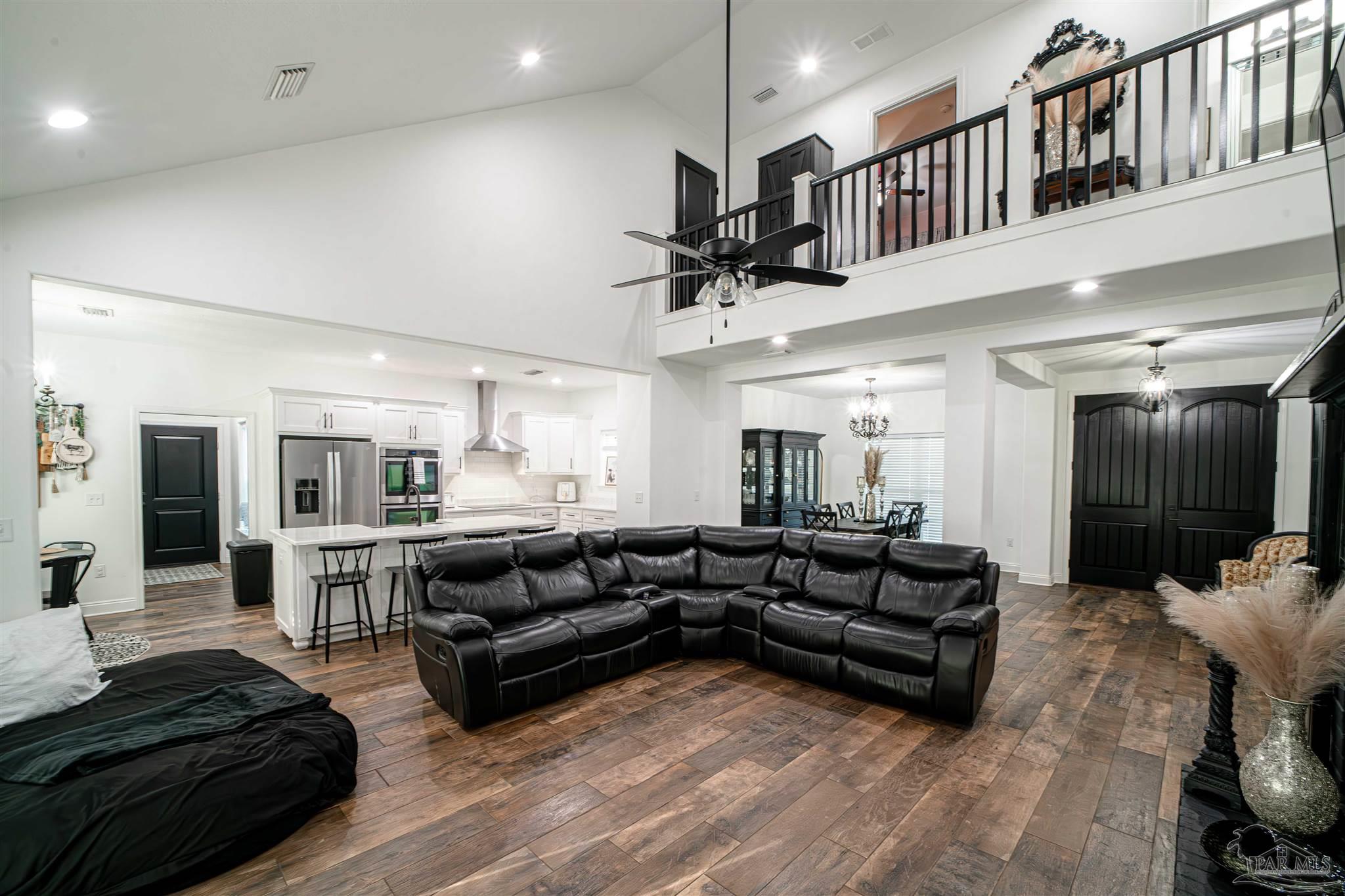 8165 Chumuckla Highway Pace, FL 32571 - Photo 20 of 50 a living room with furniture kitchen view and a chandelier