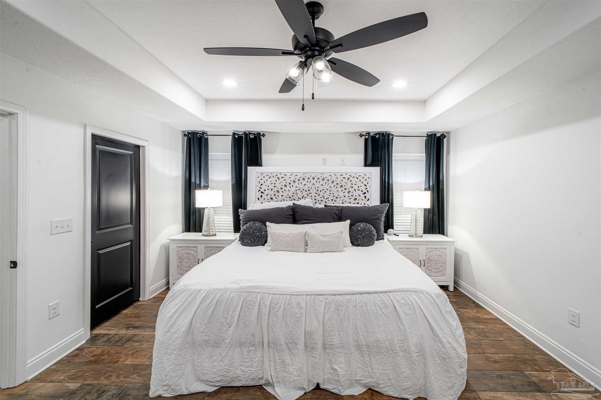 8165 Chumuckla Highway Pace, FL 32571 - Photo 23 of 50 a bedroom with a bed and a chandelier