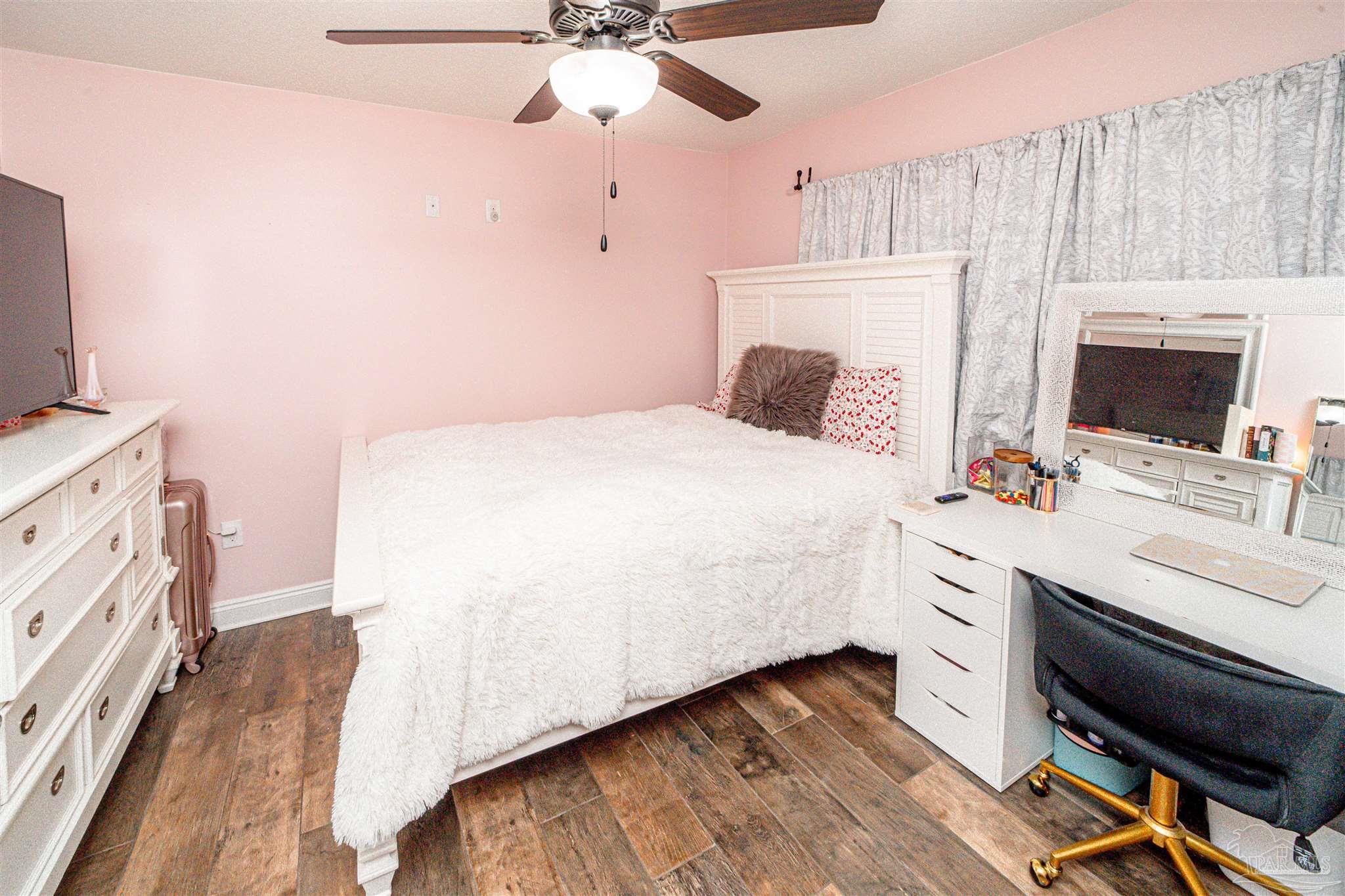 8165 Chumuckla Highway Pace, FL 32571 - Photo 36 of 50 a bedroom with a bed a flat screen tv and a fireplace